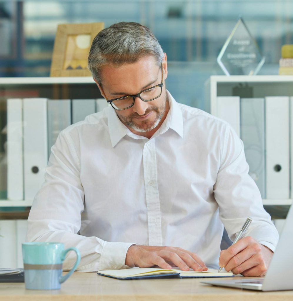 Businessman, writing in notebook and working in accounting firm for business tax, compliance and fi