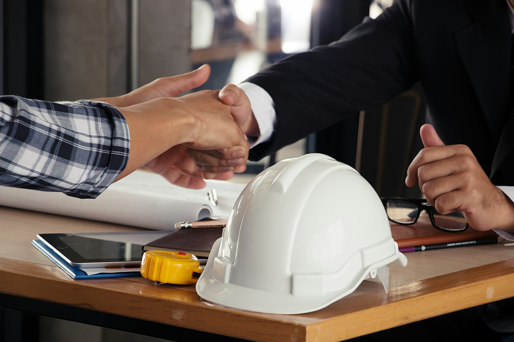Safety hat with with hand shaking background